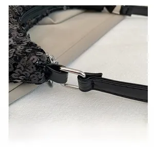 Gros plan détaillé de l'anneau métallique argenté et des paillettes noires du sac