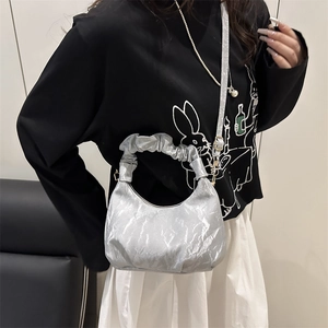 Cloud-shaped pleated handbag in silver satin with a versatile crossbody strap design