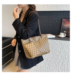 Detail of a brown checkered tote bag set with matching small pouch and slim leather strap