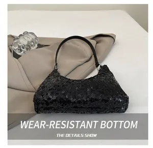Gros plan sur les paillettes noires scintillantes et les détails de la bandoulière du sac