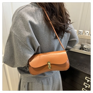Classic brown leather underarm bag with gold U-shaped metal buckle on a shoulder strap
