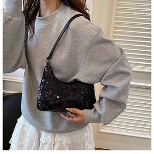 Vue détaillée du sac croissant à paillettes noires avec éclat métallique et lanière