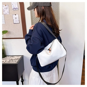 Détail du sac polochon en nylon blanc avec sangle noire et tirette orange