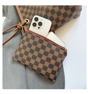 Dettaglio di borsa tote a scacchi e pochette con motivi floreali vintage e doppio scomparto