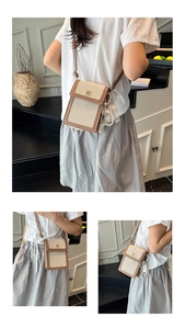 Detail view of canvas and leather mini bag with gold buckle and pearl doll charm