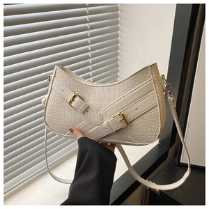 Detail of off-white faux crocodile leather shoulder bag with decorative buckle design