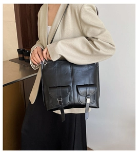 Makro-Detailansicht der schwarzen Ledertasche mit funktionalen Doppel-Fronttaschen
