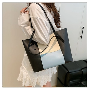 Close-up of color-block tote bag with black, beige and blue PU leather panel details