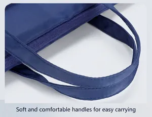 Detail view of reinforced padded handles and zipper on a navy blue laptop handbag