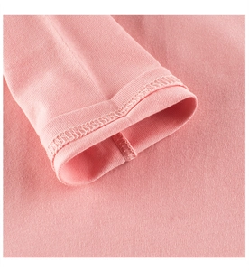 Gros plan détaillé sur le poignet en tricot rose et les coutures à double aiguille