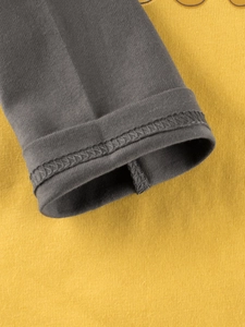Detailed close-up of cotton long sleeve cuffs with contrast grey and yellow stitching