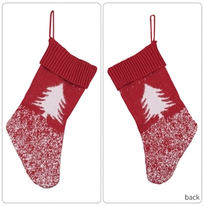 Detail of red knit Christmas stocking with white jacquard snowflake and tree patterns