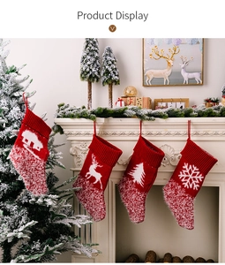 Set of four knitted Christmas stockings with snowflakes and reindeer by a fireplace