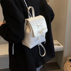 Schicker weißer Mini-Rucksack mit Schleife und Kettenriemen am Modell gezeigt