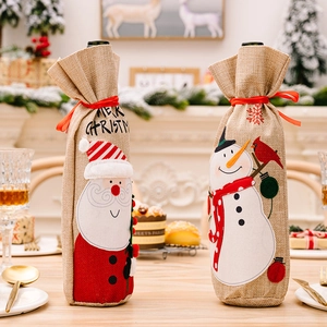 Detail of burlap Christmas wine bottle covers with Santa Claus and Snowman embroidery