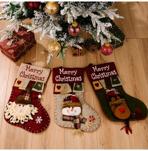 Detail of 3D Santa and snowman Christmas stockings with embroidery and festive tassels