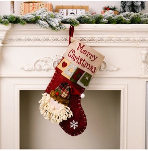 Detail of a red Christmas stocking with 3D Santa Claus hanging on a white fireplace