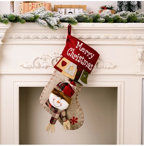 Detail of 3D snowman Christmas stocking hanging on a white fireplace mantel decoration