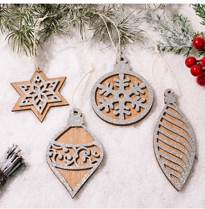 Detail of wooden Christmas ornaments with silver glitter and twine on fir branches
