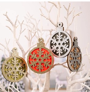 Close-up of four wooden snowflake ornaments with glitter coating and hanging ropes