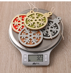 Set of four wooden snowflake Christmas tree ornaments in red green grey and brown with glitter