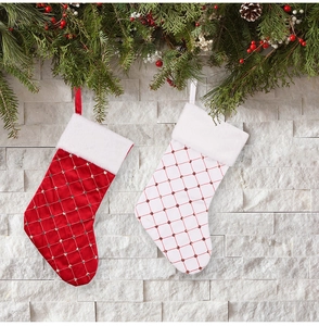 Close-up of red and white quilted satin Christmas stockings with faux fur trim