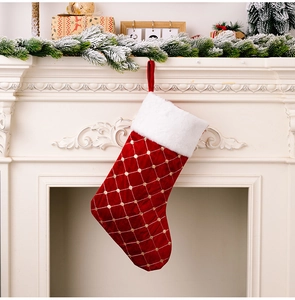 Close-up of red velvet Christmas stocking with gold lattice and white plush cuff