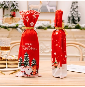 Detail of red Merry Christmas wine bottle covers with ribbons on a festive dining table