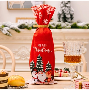 Detail of red Christmas wine bottle cover with festive patterns and golden ribbon tie