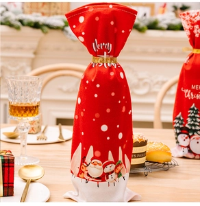 Close-up of a festive Christmas wine bottle cover with Merry Christmas print and gold drawstring