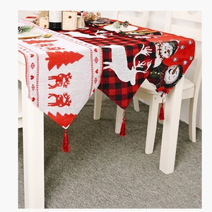 Detailaufnahme von Weihnachtstischläufer mit Karomuster, Strickdesign und roten Quasten