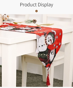 Nahaufnahme des roten gestrickten Weihnachtstischläufers mit Schneemann und Quasten