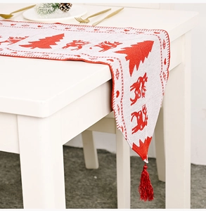 Makro-Detail von gestricktem Weihnachts-Tischläufer mit roten Hirschen und Quasten