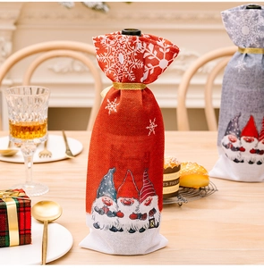 Detail van linnen kerstwijnfleshoezen met kaboutermotieven en sneeuwvlokken