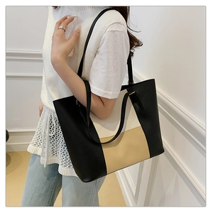 Detail of color-block tote bag featuring textured faux leather and long black shoulder straps