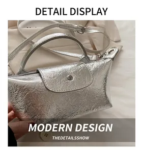 Detailed view of silver metallic pleated texture and handle on a stylish dumpling bag