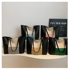 Close-up of stylish contrast color leather tote bags with adjustable gold metal buckles