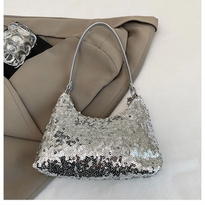 Détail d'un sac à bandoulière à paillettes argentées avec texture métallique sur une veste