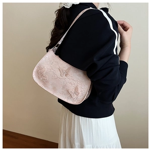 Dettaglio della borsa hobo rosa chiaro con ricami in pizzo delicato e farfalla 3D applicata