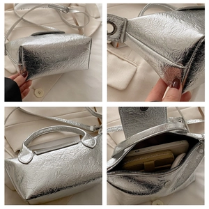 Detail view of silver metallic dumpling bag showing crinkled texture and interior storage