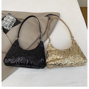 Détail de sacs baguette à paillettes noir et or sur un blazer beige et tissu blanc