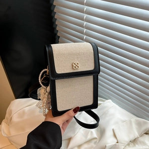 Chic canvas crossbody bag with black leather trim and golden flower clasp detail