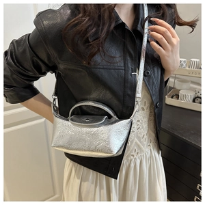 Detail of silver metallic dumpling bag with crushed pleats shown on a fashion model