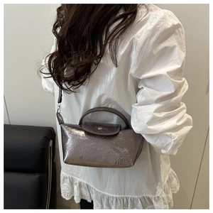 Detailed view of grey metallic textured bag with silver buckle and thin shoulder strap