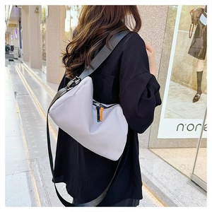 Vue détaillée de la bandoulière réglable en nylon et de la fermeture éclair sur sac gris