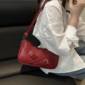 Chic red crocodile pattern underarm bag with gold buckles worn over a white shirt