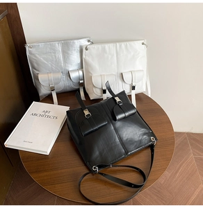 Detailansicht der Vintage-Kunstledertaschen in Schwarz, Weiß und Silber mit Metallschnallen