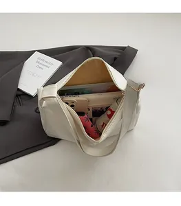 Detail shot of white large capacity tote bag holding books, phone and umbrella