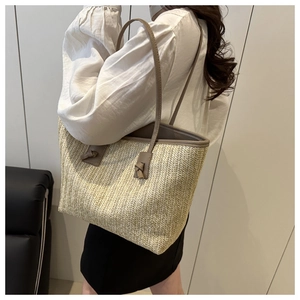 Side view of straw tote bag with brown leather straps and knot details on a model