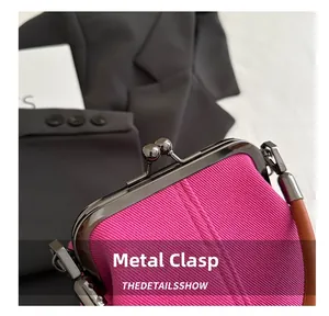 Close-up of retro gun-black metal clasp on textured magenta corduroy crossbody bag